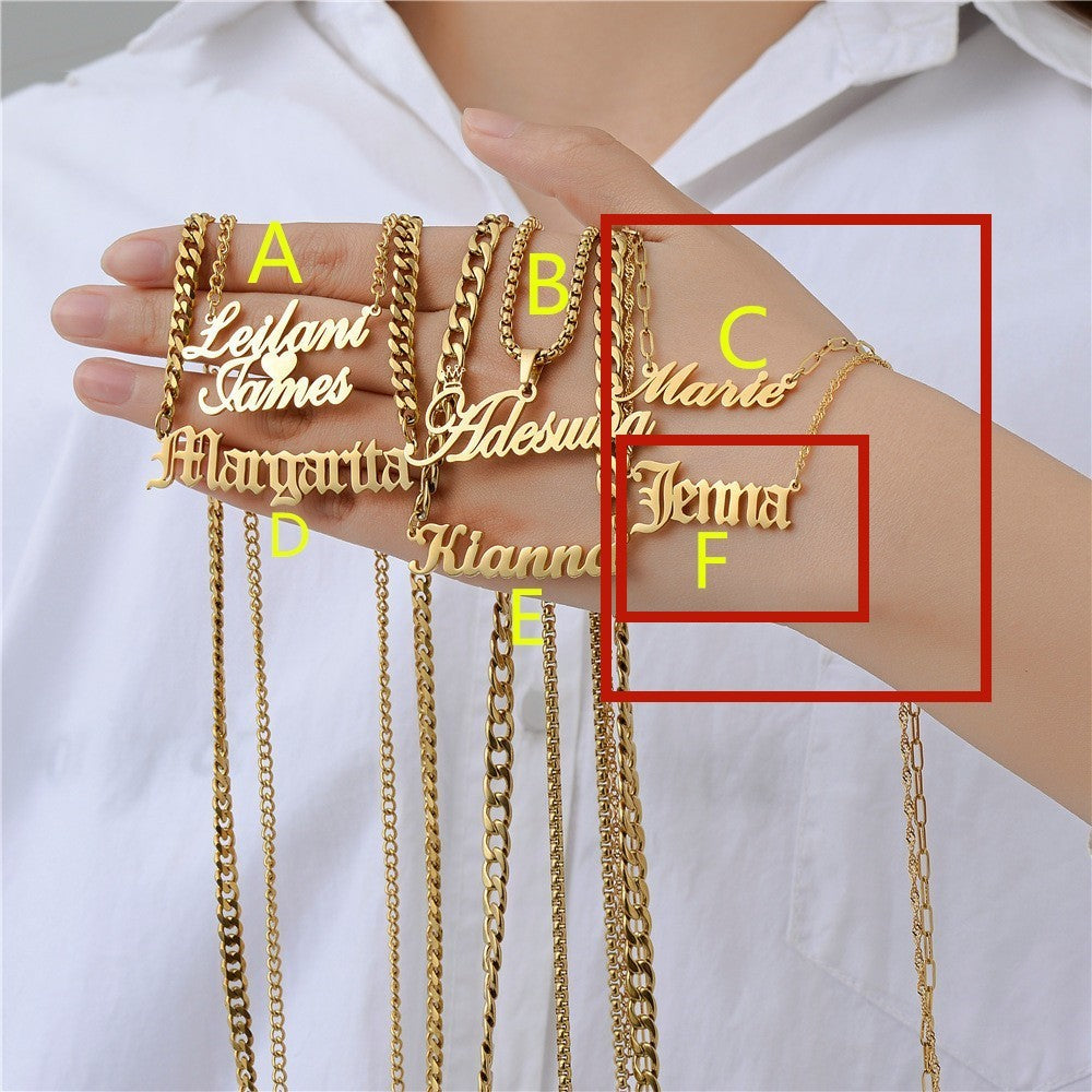 Gold personalised name necklaces held by a person against a white background