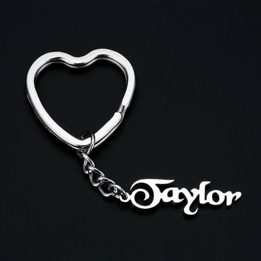 Silver heart-shaped personalised keychain with 'Taylor' on a black background
