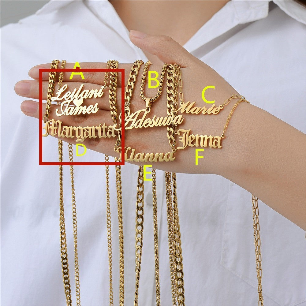 Gold personalised name necklaces held by a person against a white background
