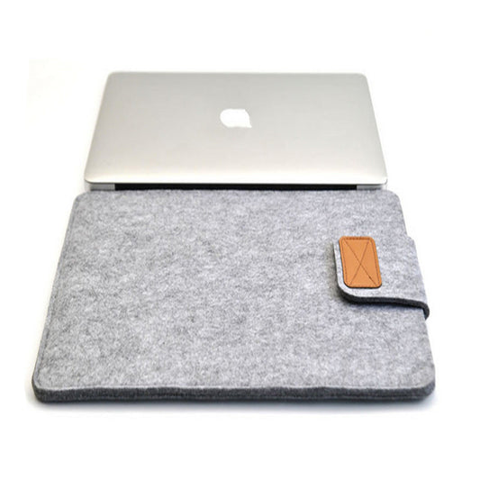 Grey laptop sleeve with a brown leather patch on a white background