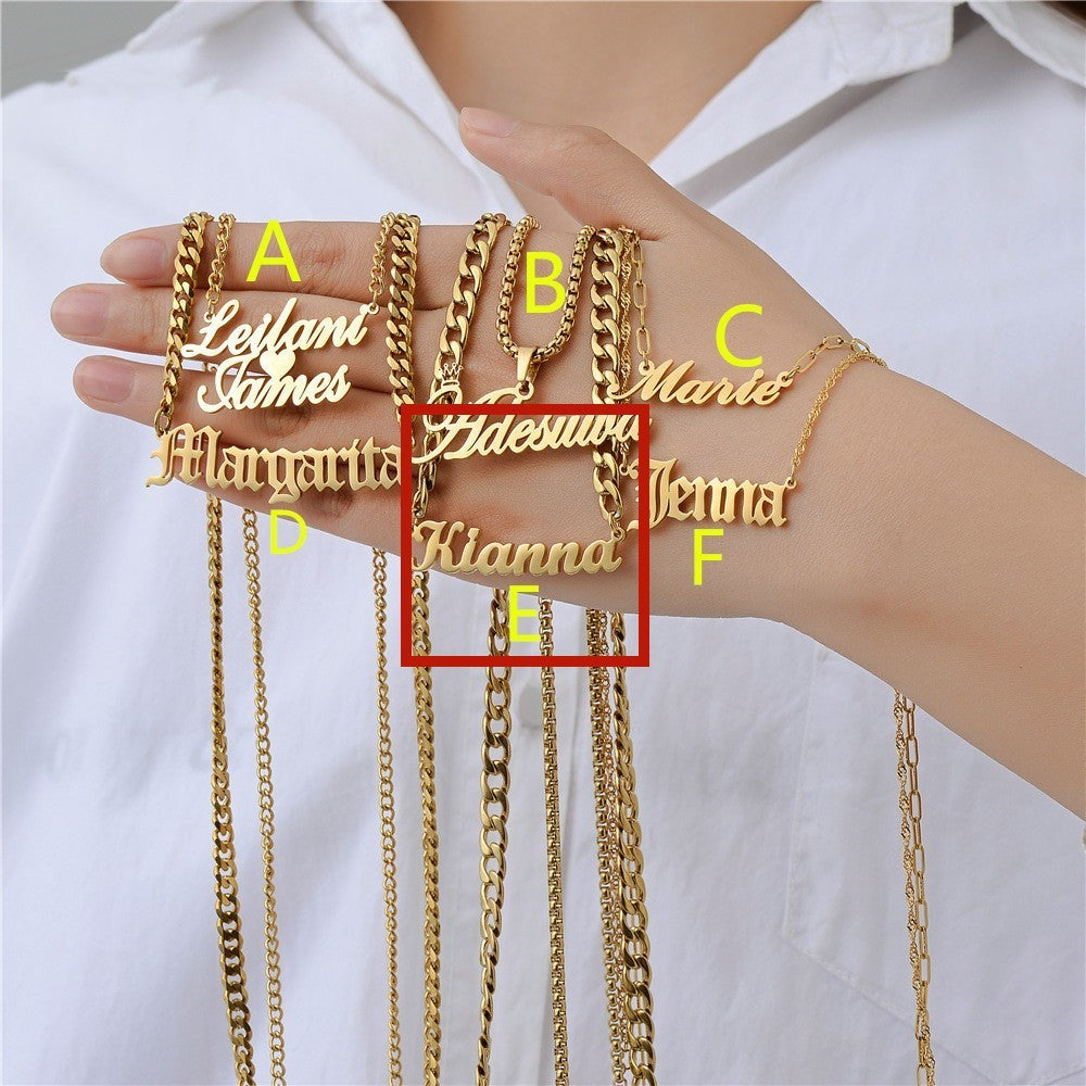 Gold personalised name necklaces held by a person against a white background