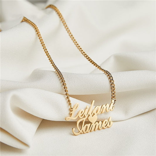 Gold personalised necklace with 'Leilani James' on a white fabric background