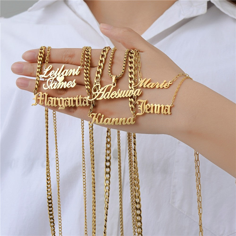 Gold personalised necklaces on a hand with a white shirt background