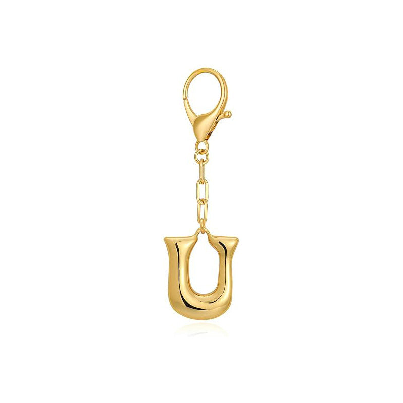 Gold letter 'U' keychain with clasp on a white background