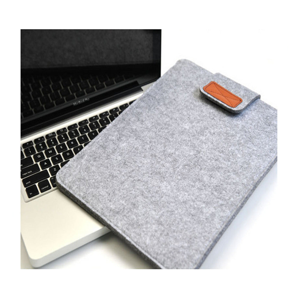 Grey felt laptop sleeve with brown leather patch on a laptop